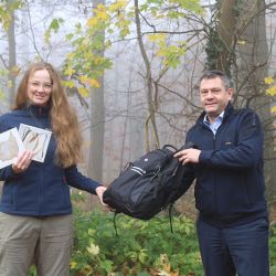 Marktbereichsleiter Stefan Koch überreicht Commerzbank-Umweltpraktikantin Katrin Schmidt den Praktikumsrucksack. Frau Schmidt präsentiert schon erste Materialien für ihre Klimawanderung / Foto: Julia König